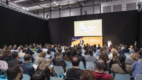 A group of people in a conference lecture